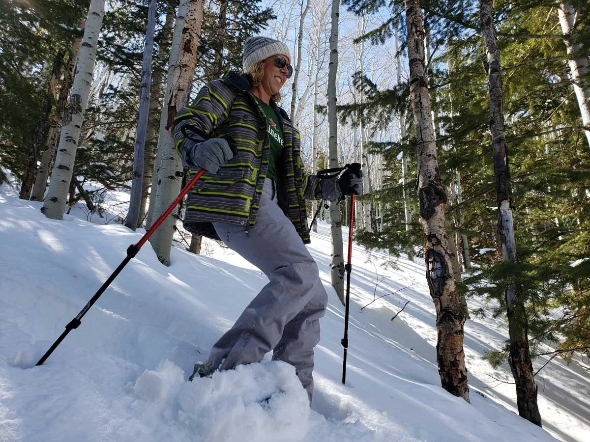 Woman solo in trees snowshoeing